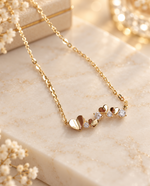 Pendentif du collier Amorette avec cœurs dorés et pierres scintillantes