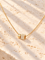 Collier Éclat cubique finition dorée avec un cube pavé de zircons et un petit cube lisse